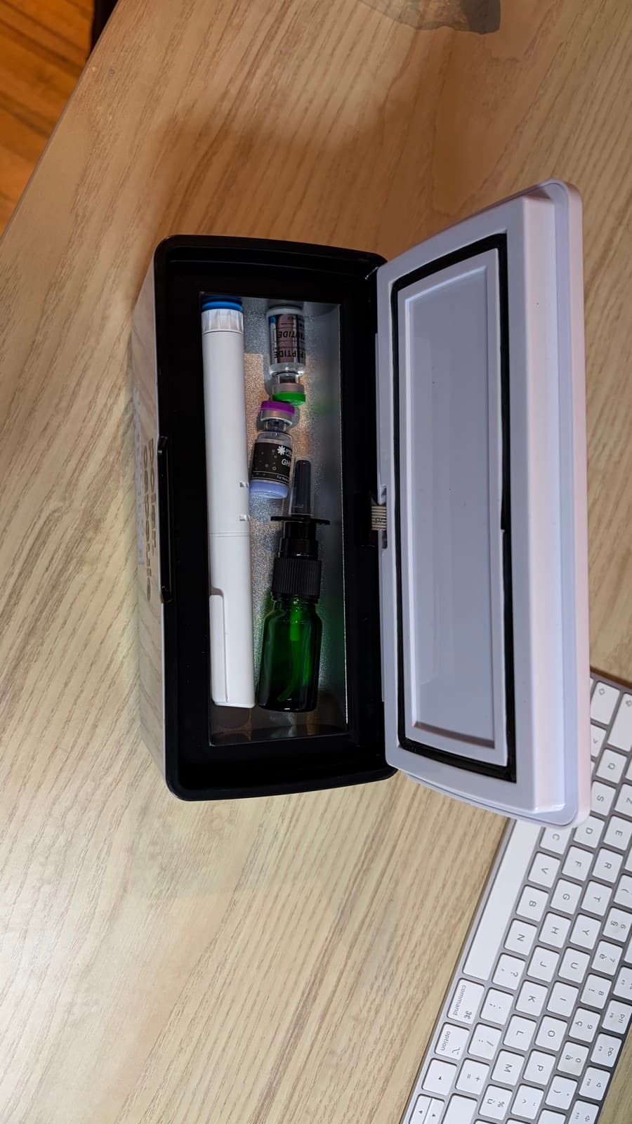 Polar Capsule ouverte sur un bureau, stylo et flacons rangés à l'intérieur